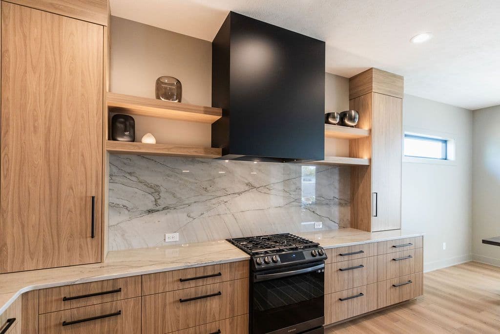 Modern kitchen design featuring wood grain cabinetry, black range hood, and marble backsplash. The kitchen includes wood shelving, a gas cooktop, and stainless steel appliances.